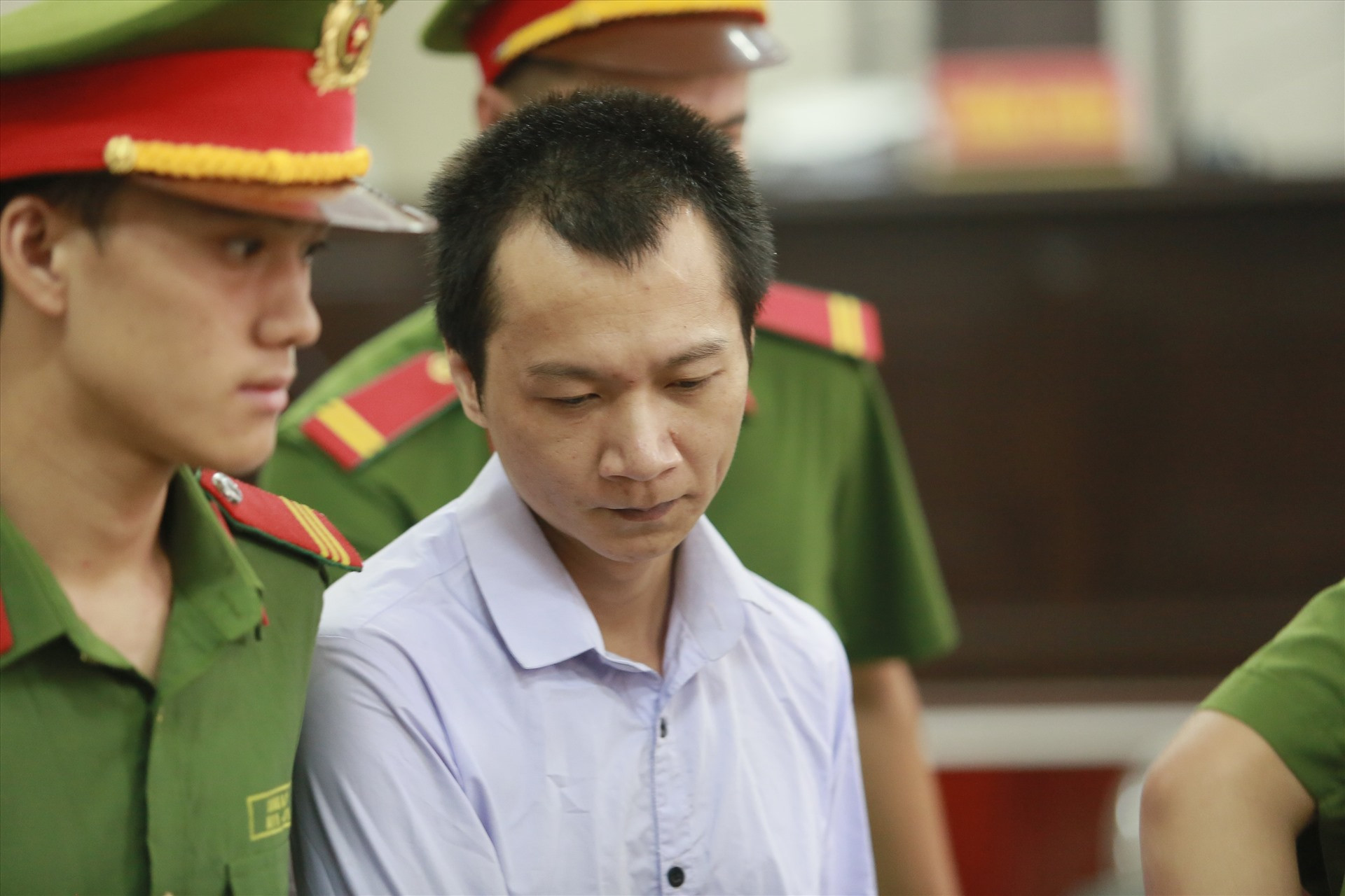 Vương Văn Hùng (áo vàng nhạt, ở giữa) một trong ba bị cáo kêu oan không phạm tội bắt, cưỡng hiếp sát hại nữ sinh giao gà, tại phiên tòa phúc thẩm vụ án Mua bán trái phép chất ma túy. Ảnh: Việt Dũng.