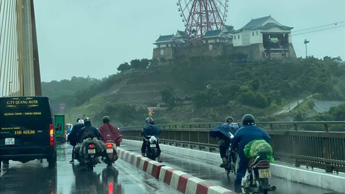 Ô tô đi chậm 'dìu' xe máy qua cầu Bãi Cháy trong gió bão