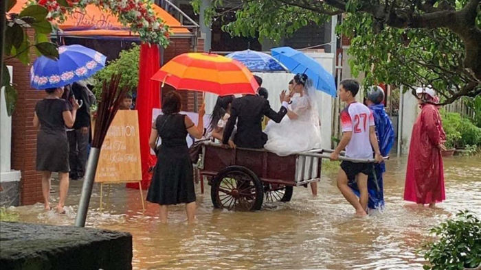 Chiếc xe kéo bất đắc dĩ trở thành xe hoa trong ngày cưới giữa mênh mông nước lụt. Ảnh từ Facebook