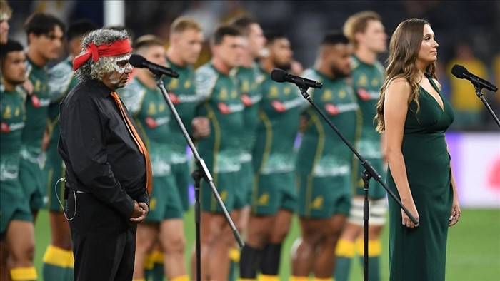 Nữ ca sĩ Olivia Fox người Wiradjuri bản địa hát quốc ca Australia bằng tiếng Eora trong một trận đấu bóng bầu dục. Ảnh AAP