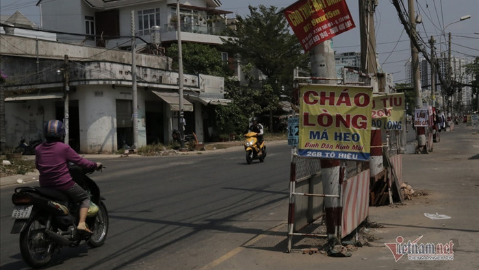 Trăm cột điện ngả nghiêng giữa đường Sài Gòn, dân luồn lách đi như 'diễn xiếc'