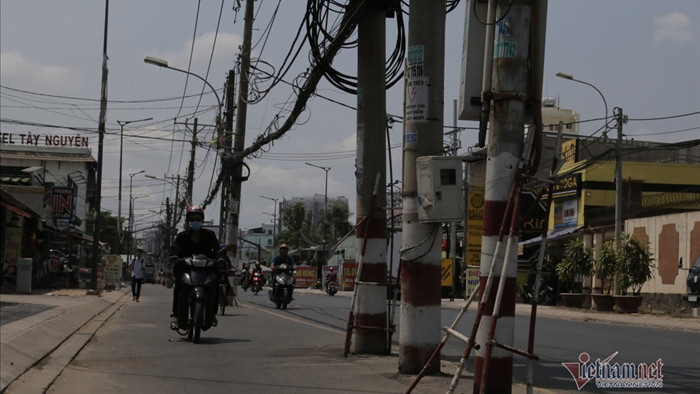 Trăm cột điện ngả nghiêng giữa đường Sài Gòn, dân luồn lách đi như 'diễn xiếc'