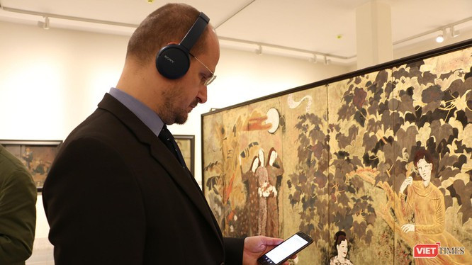Khách thăm quan xem thông tin tác phẩm trên app iMuseum VFA tại Bảo tàng Mỹ thuật Việt Nam