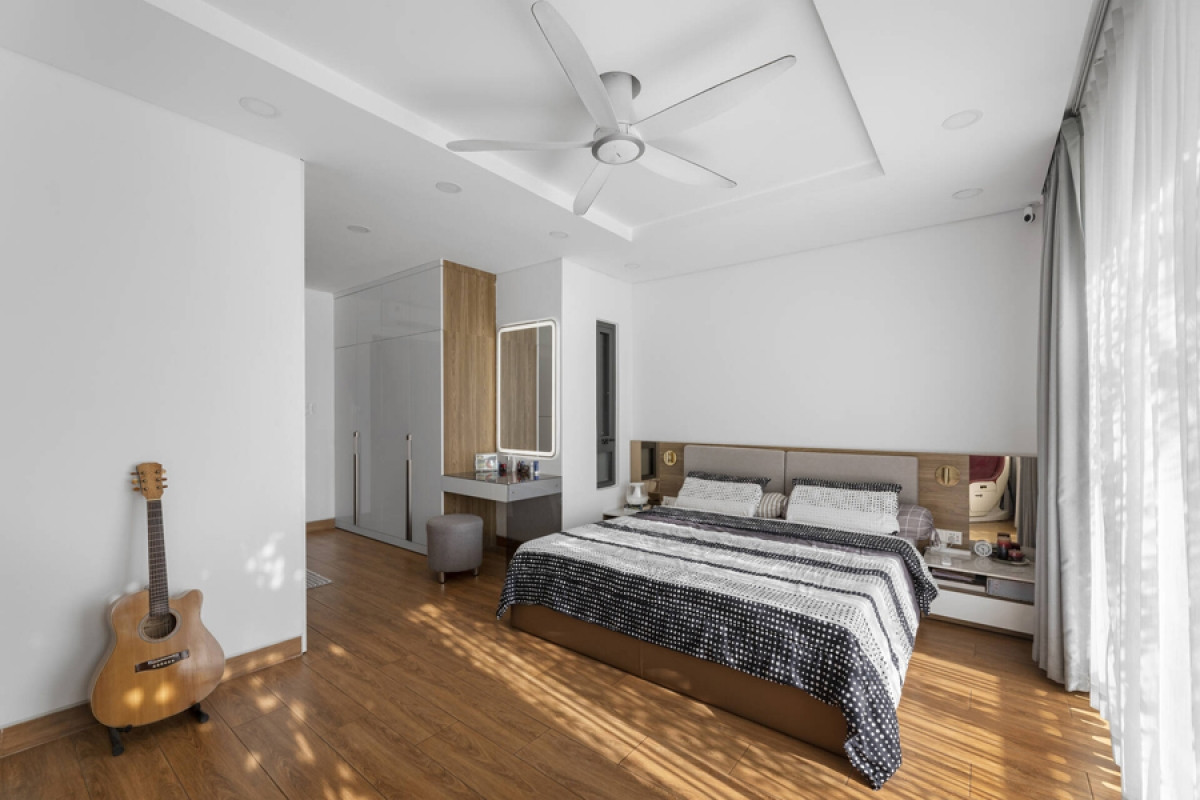 Phòng ngủ chính nằm ở phía trước nhà. Nội thất hiện đại và đơn giản với màu trắng chủ đạo kết hợp với màu nâu sáng của gỗ cho cảm giác gần gũi, thoải mái.
