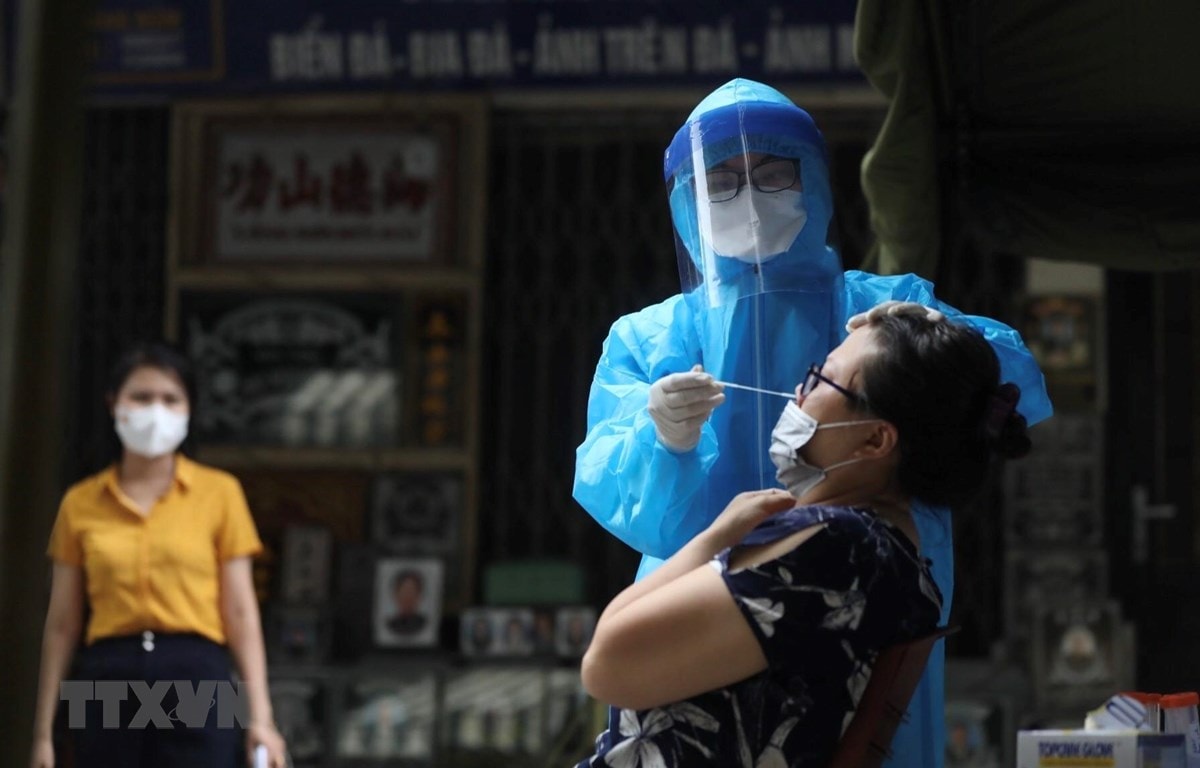 Nhân viên y tế lấy mẫu xét nghiệm COVID-19 cho các trường hợp có nguy cơ cao tại khu vực liên quan đến ca dương tính với SARS-CoV-2. (Ảnh: Minh Quyết/TTXVN)