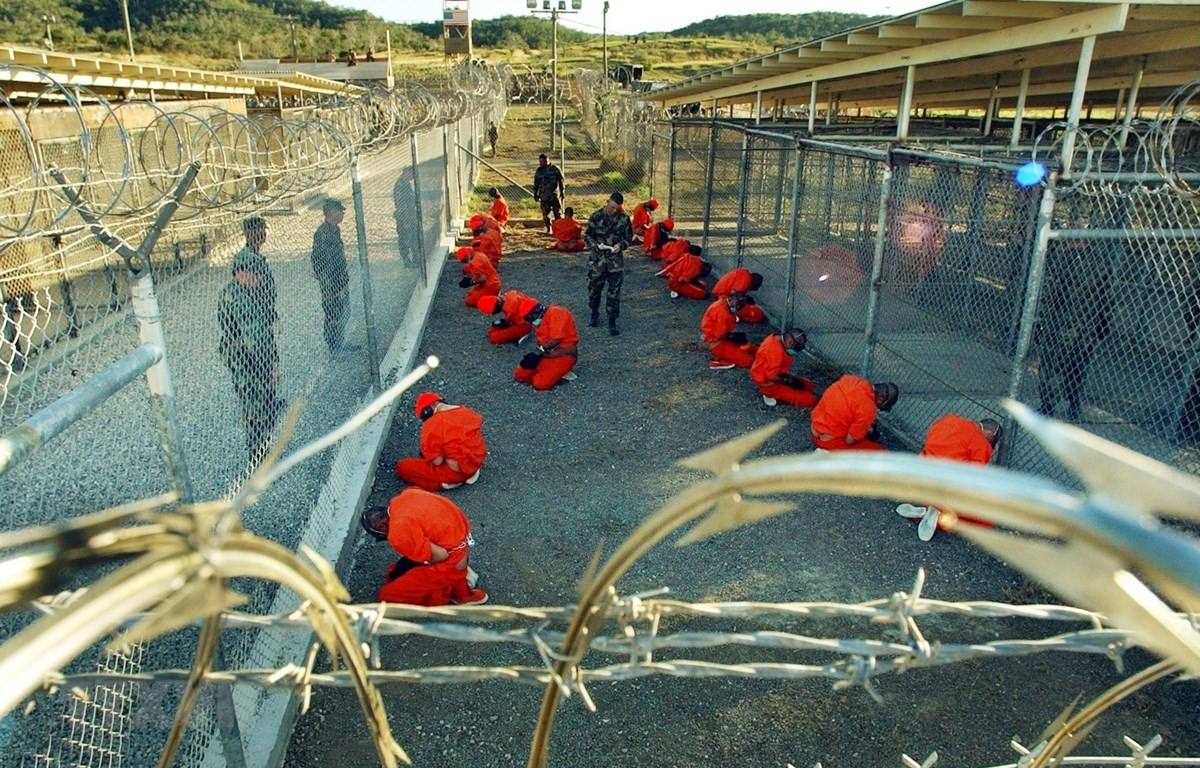  Các tù nhân bị giam giữ dưới sự giám sát của cảnh sát quân sự Mỹ tại nhà tù quân sự Guantanamo ngày 11/1/2002. (Ảnh: AFP/TTXVN)