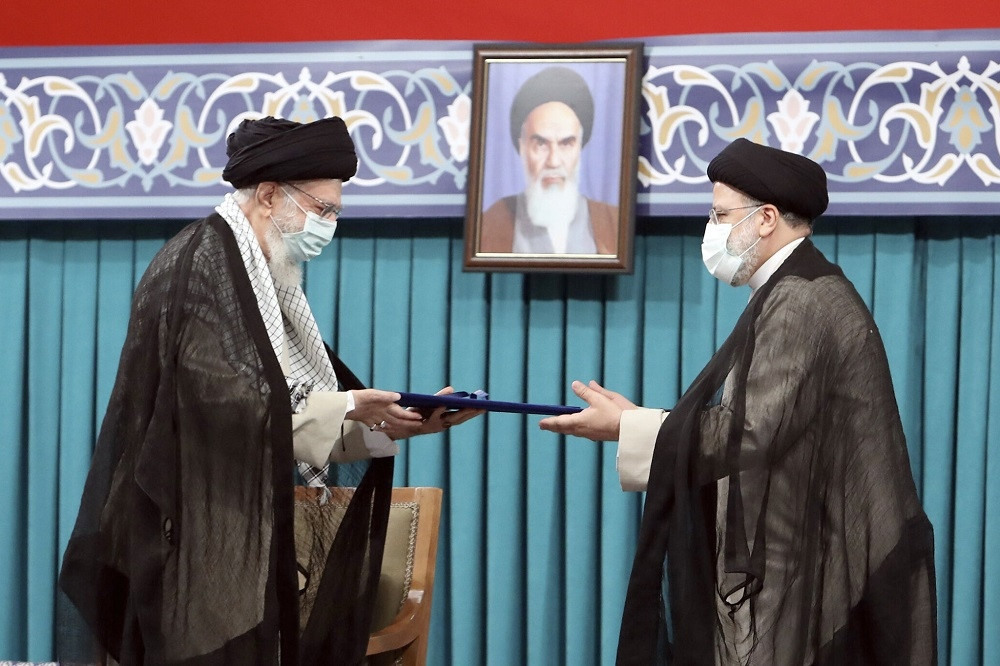 (08.03) Ông Ebrahim Raisi tiếp nhấn sắc lệnh từ Lãnh tụ tối cao Iran Khamenei. (Nguồn: AFP)