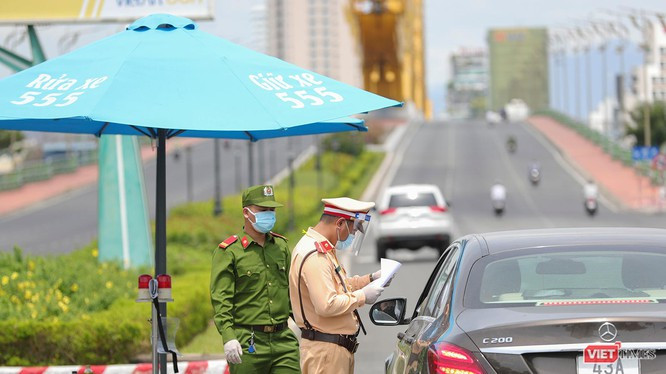 Lực lượng công an tại chốt kiểm soát dịch trên địa bàn TP Đà Nẵng kiểm tra giấy đi đường của người dân