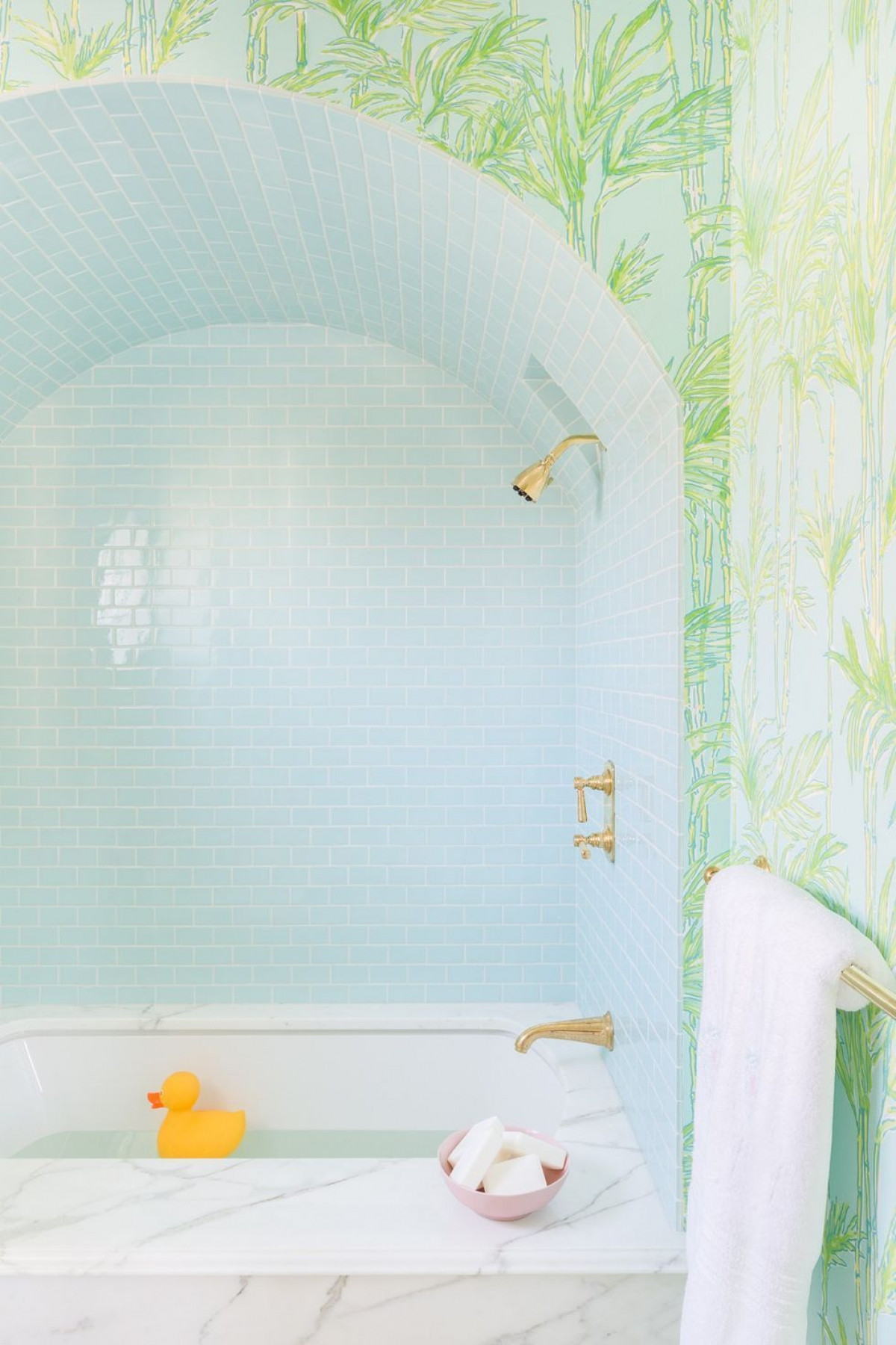 Bồn tắm bằng đá cẩm thạch, giấy dán tường lấy cảm hứng từ thực vật, gạch lát màu xanh dịu nhẹ khiến phòng tắm này trở nên đầy màu sắc.