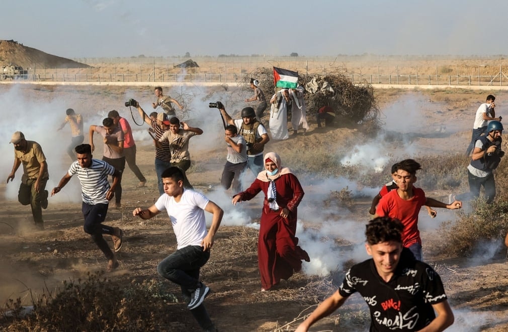 Người biểu tình và các nhà báo Palestine chạy khỏi làn đạn hơi cay do lực lượng an ninh Israel bắn trong cuộc biểu tình dọc theo hàng rào biên giới, phía Đông Khan Yunis ở phía Nam Dải Gaza. (Nguồn: Getty) Ảnh ấn tượng tuần 23-29/8: Philippines vật lộn với Covid-19; bom đạn, nước mắt, ‘thành trì’ Panjshir và mải miết trốn chạy khỏi Afghanistan