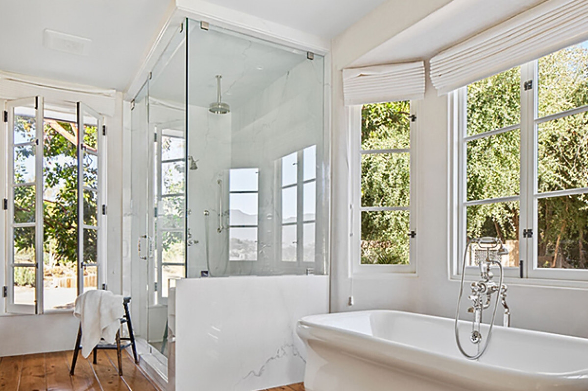 Sàn gỗ cứng màu nâu là bổ sung hoàn hảo cho không gian phòng tắm với màu trắng chủ đạo.