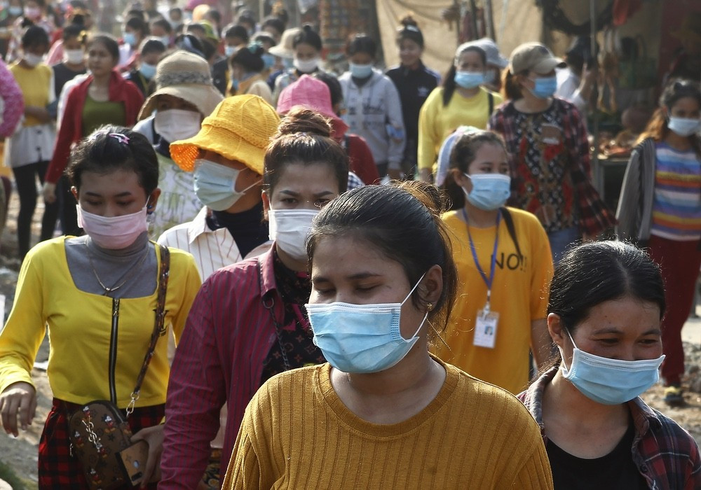 Garment factory workers wear face masks as they walk out at the end of their work shift near Phnom Penh, Cambodia, Friday, Feb. 26, 2021. (nguồn: AP)