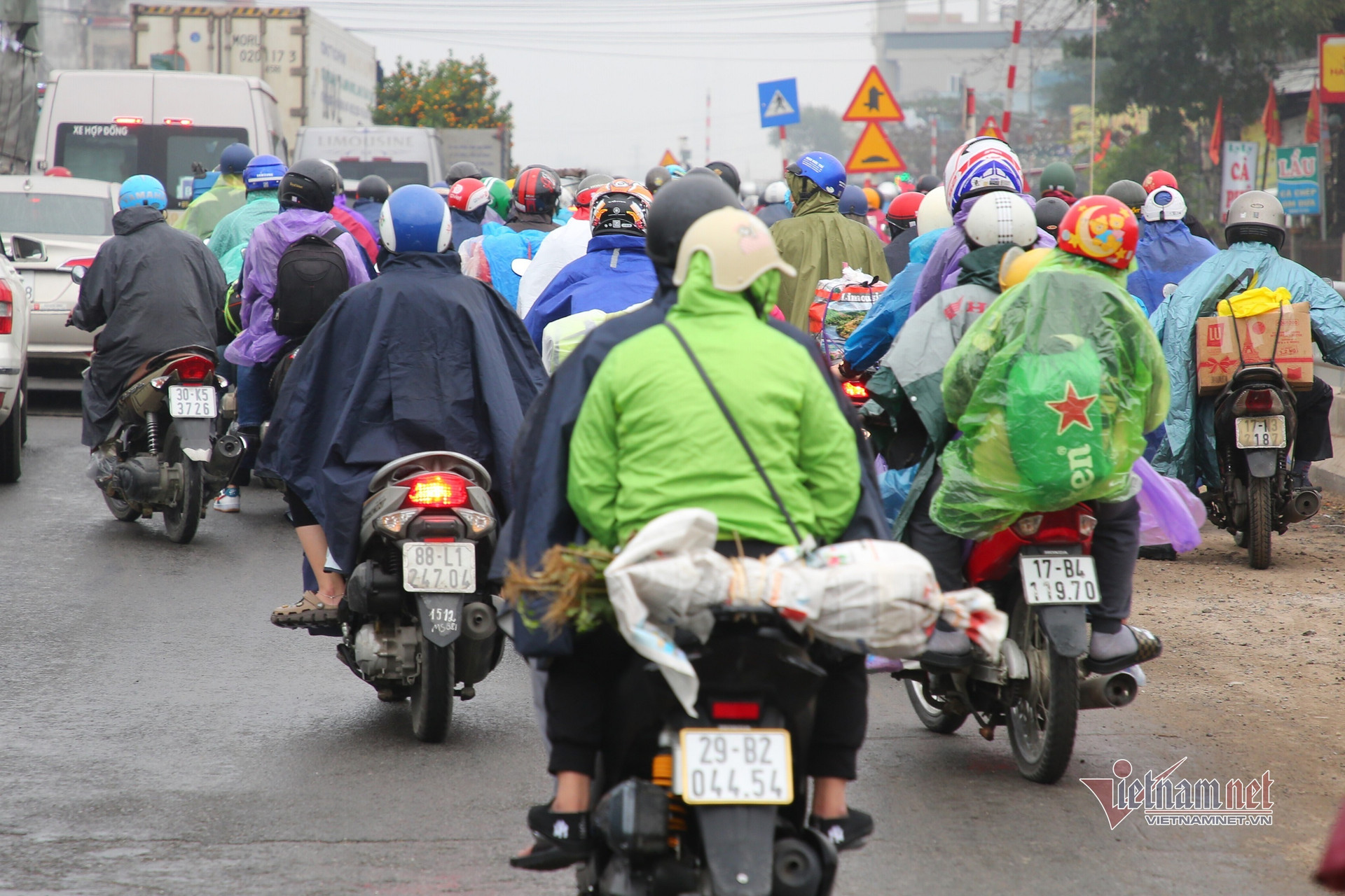 Trùm kín áo mưa, nghìn người ùn ùn rời phố về quê ăn Tết
