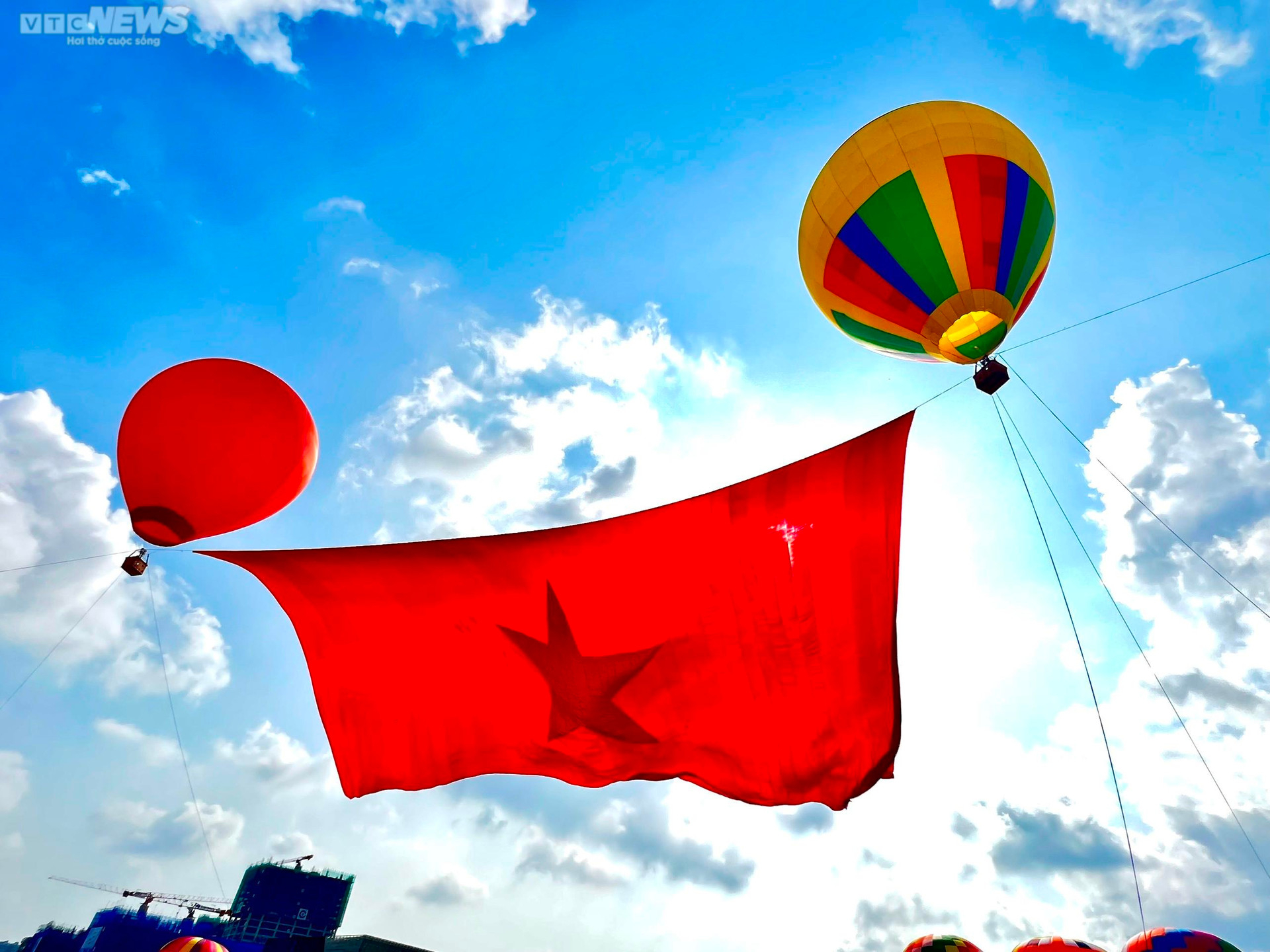 Người dân TP.HCM đội nắng xem khinh khí cầu kéo đại kỳ 1.800 m2 - 3