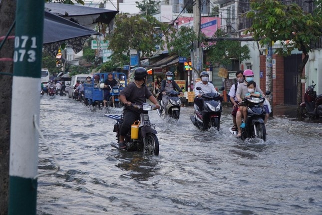 Người dân TPHCM bì bõm về nhà khi triều cường dâng cao ảnh 12