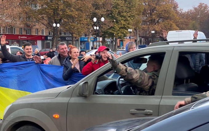 Người dân cầm cờ chào đón đoàn xe quân sự Ukraine tại Kherson, ngày 11/11. Ảnh: Twitter/IgorKyivskyi.