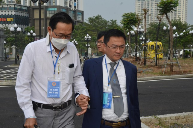Cựu Thứ trưởng Bộ Y tế Cao Minh Quang chống gậy đi tập tễnh đến tòa ảnh 1