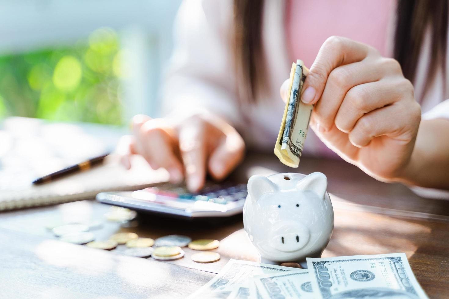 closeup-of-business-woman-hand-putting-money-coin-into-piggy-bank-for-saving-money-saving-money-and-financial-concept-free-photo.jpg