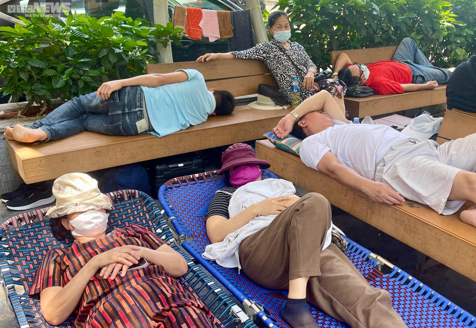 Người nhà bệnh nhân vật vã dưới nắng nóng hơn 50 độ C ở Hà Nội - 9