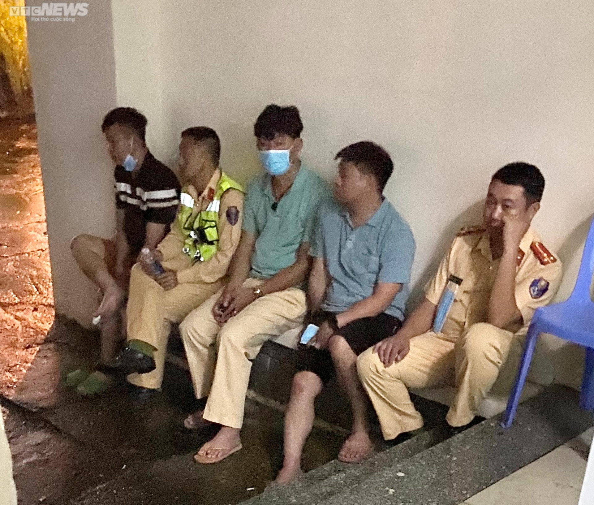 Anh Trung (trái) và anh Hưng (thứ 2 từ phải qua) thất thần ngồi cùng các đồng đội ở khu vực nhà vĩnh biệt Trung tâm Y tế huyện Đạ Huoai. (Ảnh: Đại Việt)