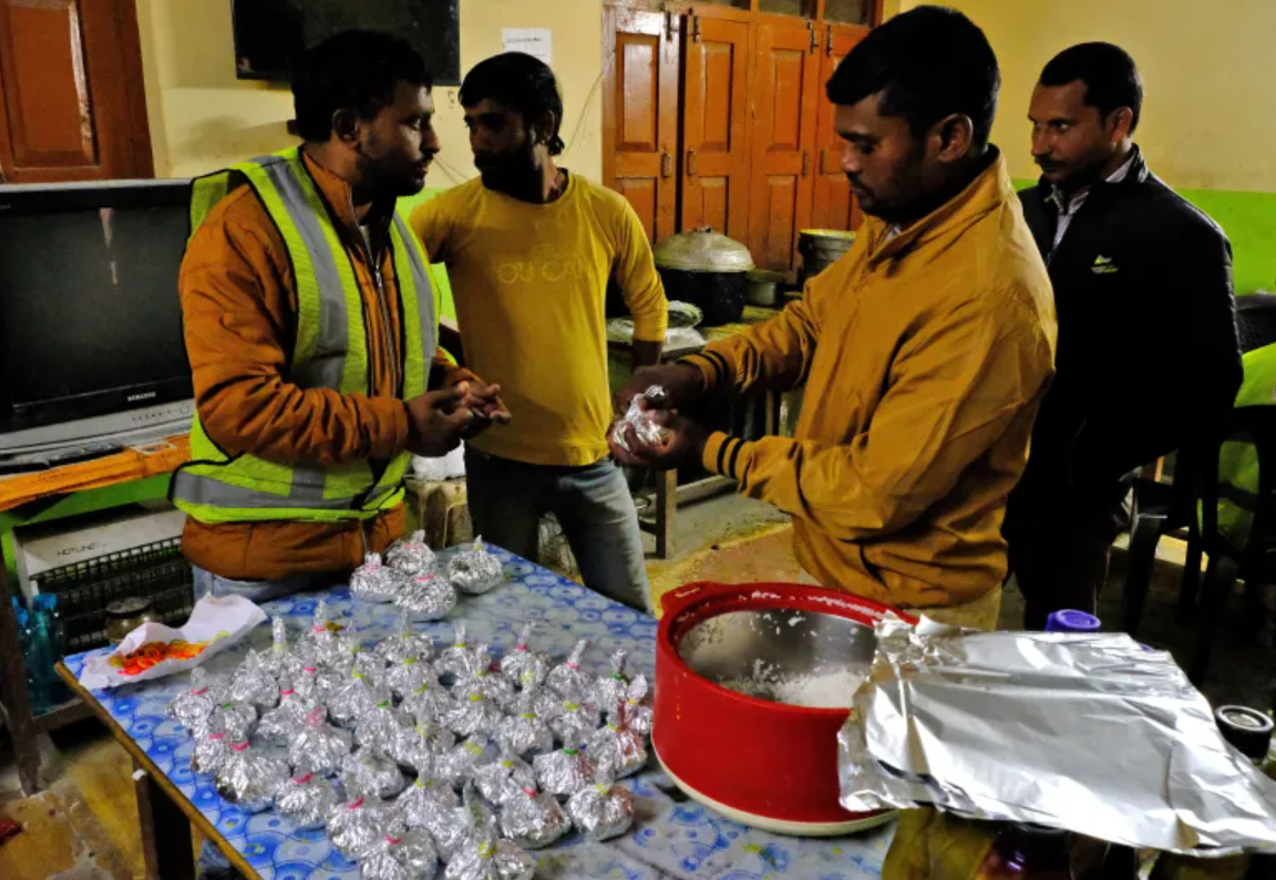 Nhân viên cứu hộ đóng gói gạo gửi đến các công nhân mắc kẹt. (Ảnh: Reuters)