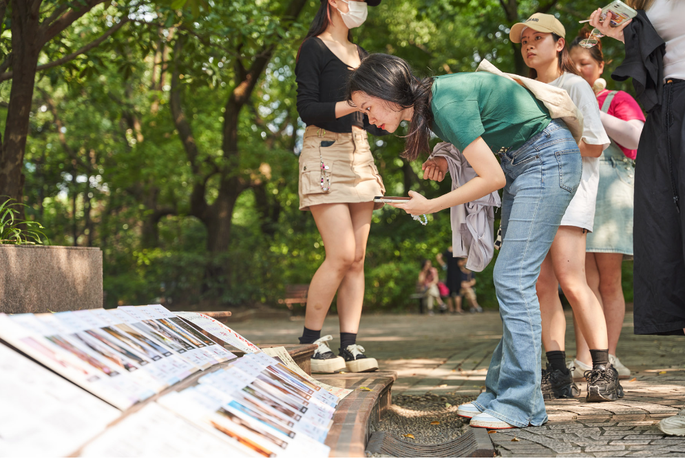 Một người phụ nữ xem áp phích lý lịch thú cưng tại công viên Nhân dân ở Thượng Hải, Trung Quốc. (Ảnh: Sixthtone)
