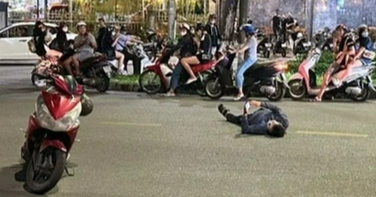 Người đàn ông nằm giữa đường xem điện thoại đang phải điều trị tâm lý