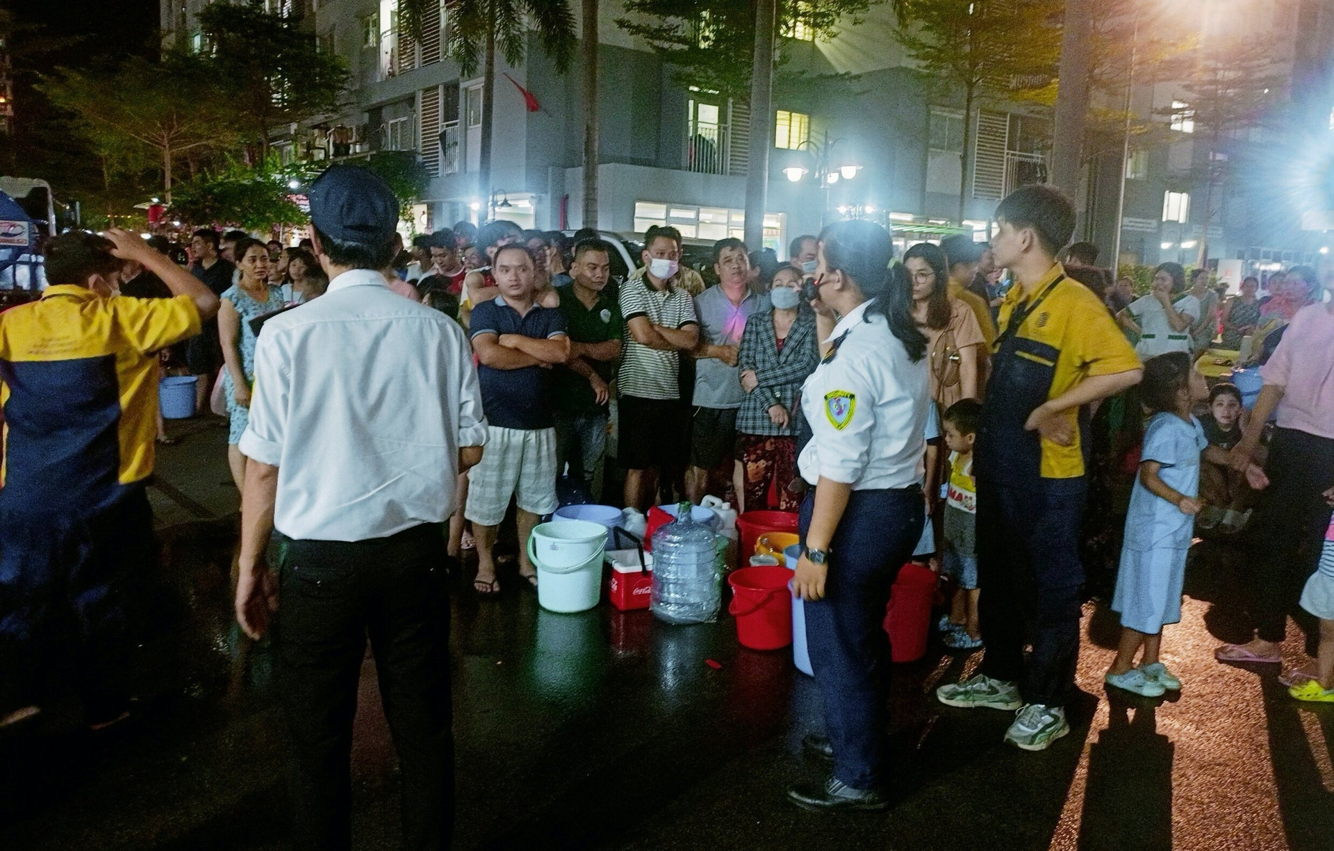 Hàng nghìn cư dân chung cư Ehomes Phú Hữu mang theo xô, chậu để hứng nước từ xe bồn về sử dụng.