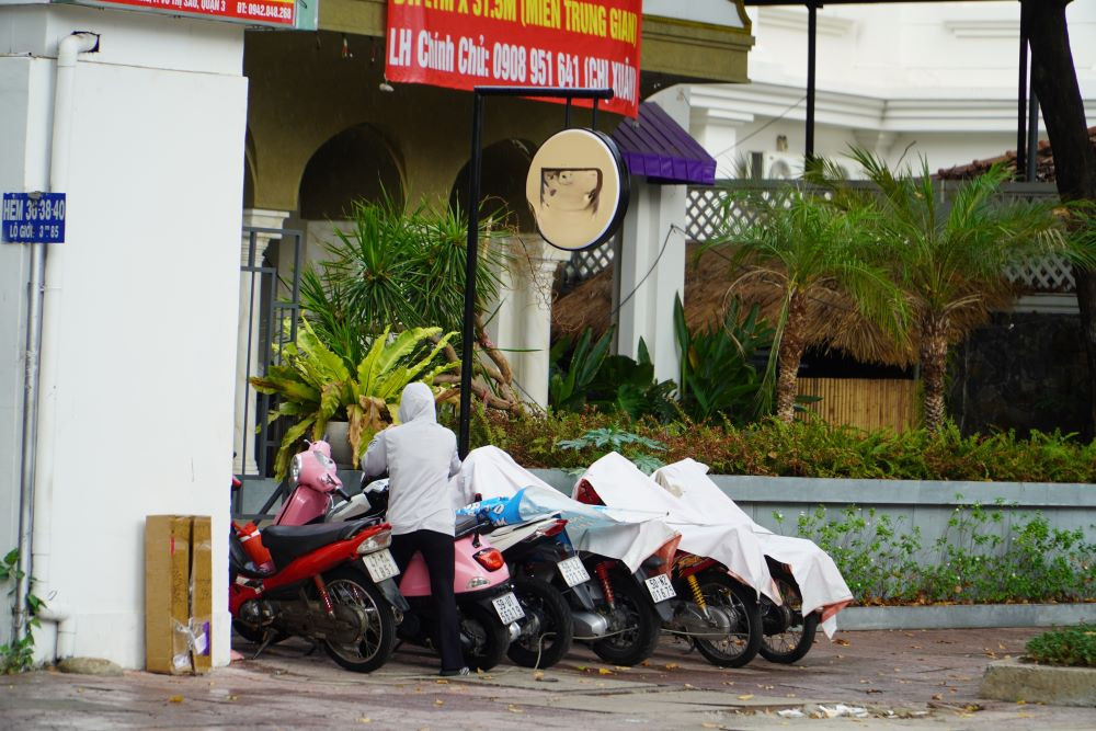 Nhiều xe máy trên vỉa hè đường Trần Quốc Thảo (Quận 3) được phủ áo mưa tránh ướt.
