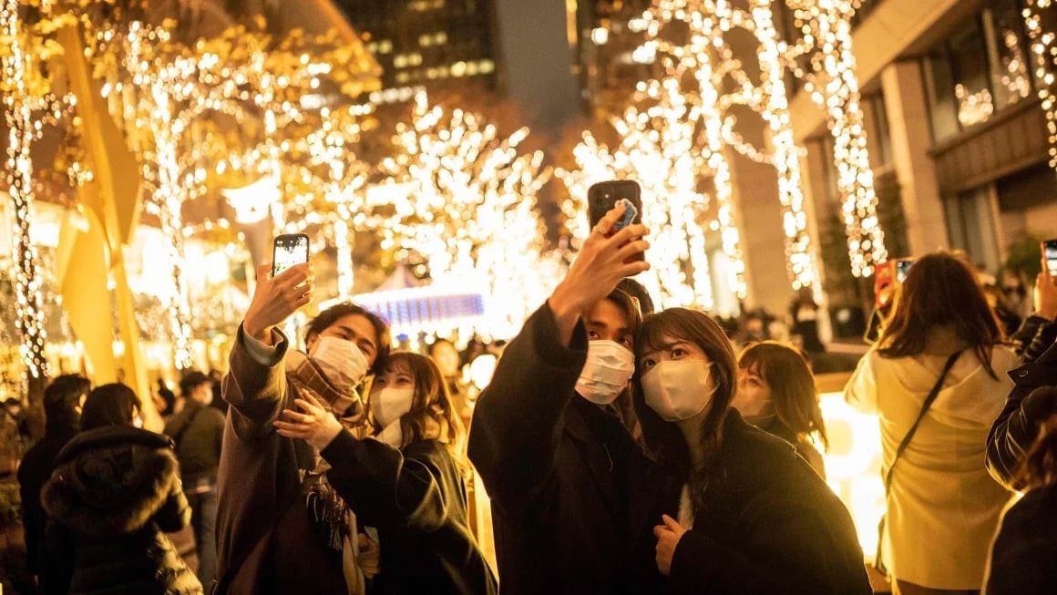 Các cặp đôi chụp ảnh cùng nhau trên phố đèn Giáng sinh ở Tokyo. (Ảnh: Getty)