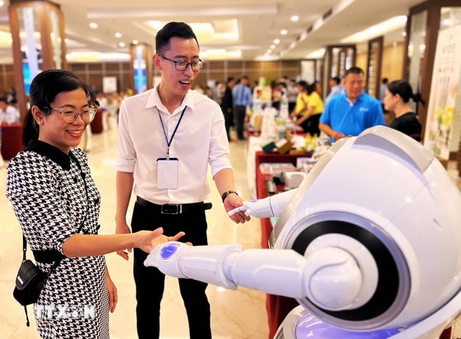 Tương tác với robot. (Ảnh: Ánh Tuyết/TTXVN) ttxvn-doi-moi-sang-tao-robot.jpg