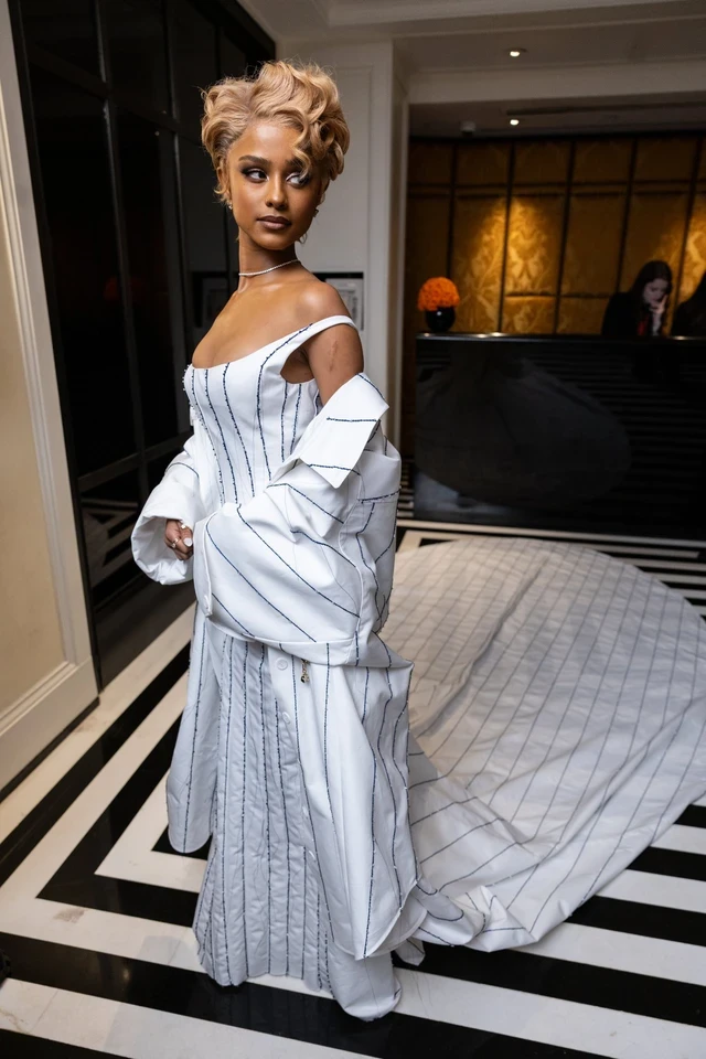 Tyla cực slay trong mẫu váy được custom riêng từ Jacquemus, lấy cảm hứng từ André Leon Talley, khoe khéo vòng 1 căng đầy quyến rũ. Điểm sáng trong tạo hình này chính là kiểu tóc ngắn được uốn xoăn ngẫu hứng nhưng không kém phần quý phái, sang trọng.