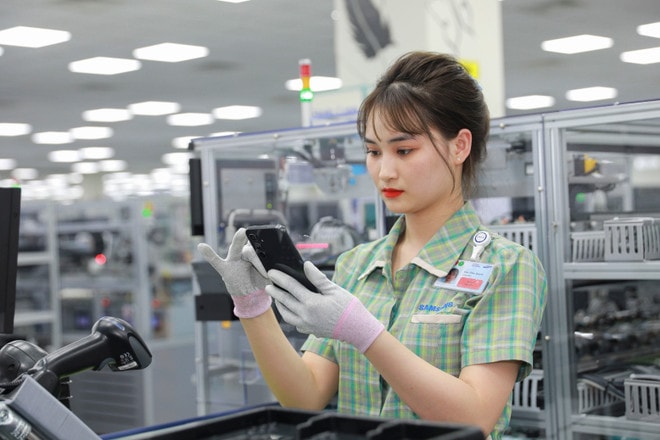 Mức thuế đối ứng 20%, kim ngạch xuất khẩu giảm khoảng 9-10% và tác động cuối cùng là làm GDP giảm khoảng 0,8 điểm phần trăm. (Ảnh: Vietnam+) nhan-vien-samsung-dang-lam-viec-tai-day-chuyen-san-xuat-dien-thoai-2.jpg