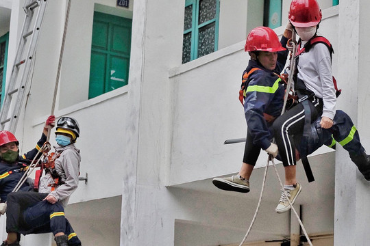 Lính cứu hỏa đu dây đưa nạn nhân mắc kẹt thoát khỏi đám cháy nhà cao tầng