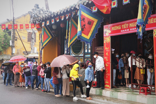 Ảnh: Người dân đội mưa xếp hàng chờ vía chùa Ông ở phố cổ Hội An