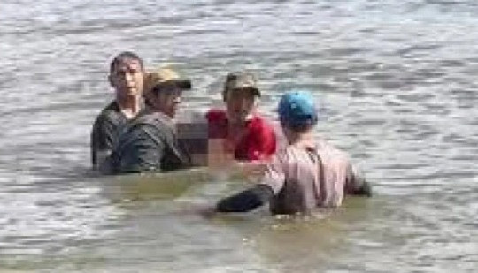 Một nam giới bị trói chân tay, buộc vào tảng đá trôi dạt trên biển