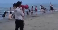 Người bảo vệ bãi biển bế bé gái 4 tuổi bị lạc đi tìm bố mẹ