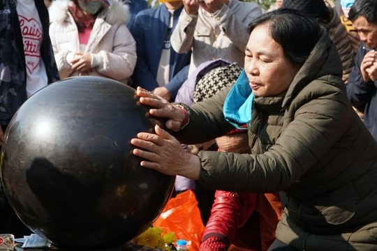 Dòng người đi quanh huyệt đạo, xoa tiền lên quả cầu đá ngày "mở cổng trời"