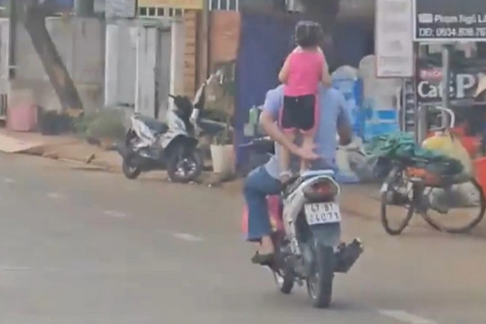 Người đàn ông cho bé gái 'làm xiếc' trên yên xe máy
