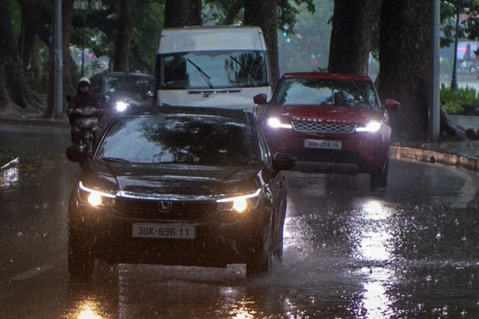 Trời Hà Nội tối sầm do ảnh hưởng mưa bão, xe cộ phải bật đèn giữa ban ngày