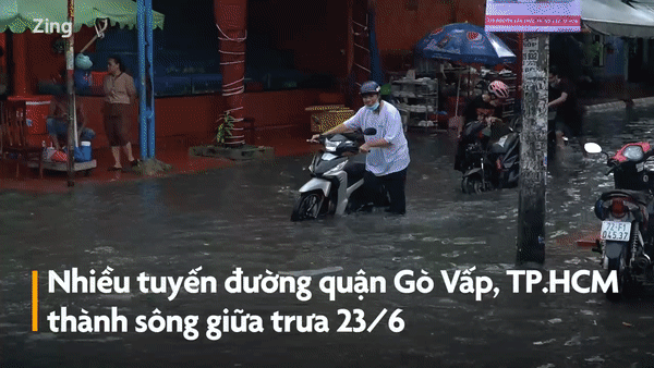 Người dân TP.HCM dắt xe lội nước sau trận mưa giữa trưa